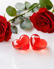 two red hearts on a white background with red and white roses