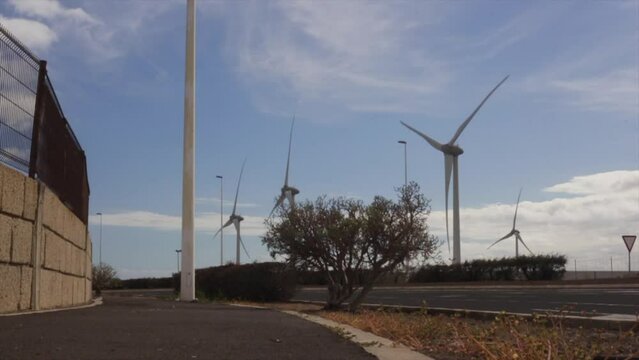 Panoramic image of wind farm with multiple wind turbines in motion, emphasizing importance of renewable energy.