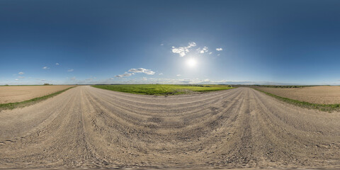 360 hdri panorama on gravel road with marks from car or tractor tires with clouds on blue sky in...
