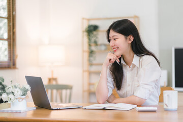 Obraz premium Asian businesswoman is using a laptop computer and working with a calculator and documents, conducting financial planning for investments and analyzing the financial report.