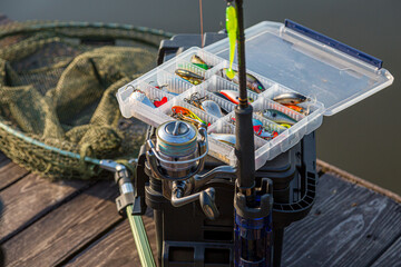 A large fisherman's tackle box fully stocked with lures and gear for fishing.fishing lures and accessories. fishing spinning. Kit of fishing lures. - obrazy, fototapety, plakaty