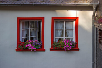 Fototapeta na wymiar red windows with flowers - old buiding in Treis-Karden, Germany