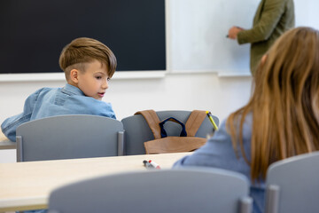 Kids at school sitting at the lesson and looking involved