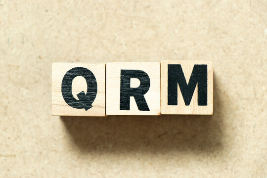 Alphabet letter block in word QRM (Abbreviation of Quality Risk Management) on wood background