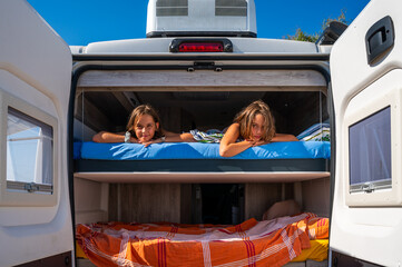 Family waking up in a campervan on the beach. - obrazy, fototapety, plakaty