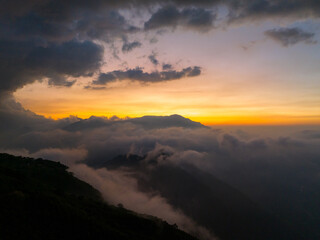 Sea of cloud over mountain peak at sunset