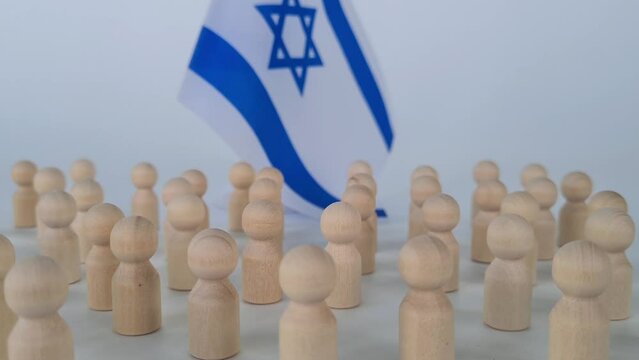 Group of people figurines and small flags of Israel. Special man to the crowd traitor