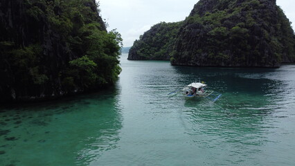 Coron's Blue Lagoon, dotted with boats, offers a tranquil vacation scene amidst crystal waters.