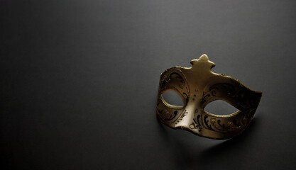 Gold tone Venetian carnival colombina mask with painted ornaments. Minimal composition - a mask on...