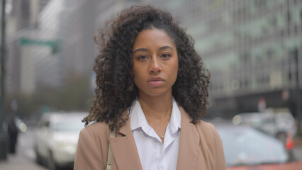 Young black business woman serious face portrait on city street - obrazy, fototapety, plakaty