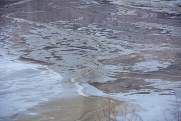Muddy waters in a decantation pond. Toxic residuals from a copper mine decating in a settling basin