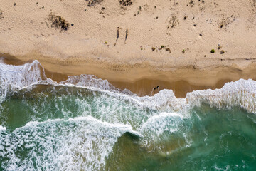 Aerial view of ocean waves washing a sandy shoreline