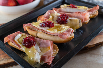 Baked baguette sandwich with camembert, ham and cranberries