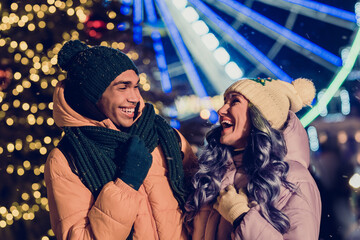 Photo of dreamy funny african guy lady dressed coats enjoying x-mas time together outdoors urban ferris wheel fair park