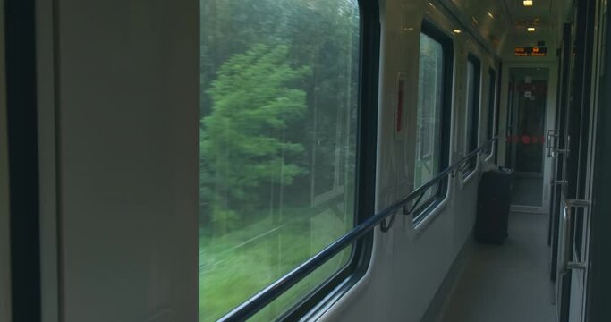 Empty carriage of moving intercity train inside. Train compartment interior corridor, wagon. No people. Journey in rail. Passenger train move with high speed in countryside. Travel by public transport