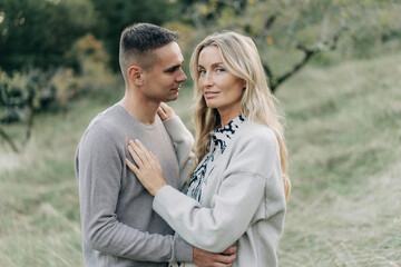 Portrait of a beautiful blond graceful woman with her handsome boyfriend in  nature.