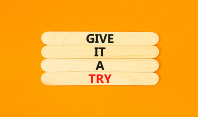 Give it a try symbol. Concept word Give it a try on beautiful wooden stick. Beautiful orange table orange background. Business give it a try concept. Copy space.