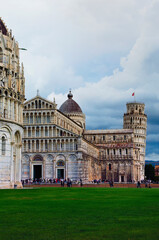 Scenic landscape view of Pisa Baptistery, Pisa Cathedral and Leaning Tower of Pisa against stormy sky and gloomy clouds. Notable landmark of Pisa, Italy. UNESCO World Heritage Site