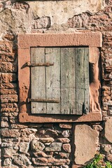 Vertical of a wooden window of an old, rural stone building