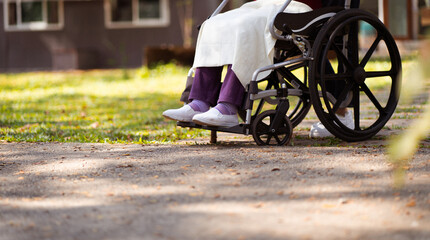 Obraz premium Nursing home. Young caregiver helping senior woman in wheelchair.