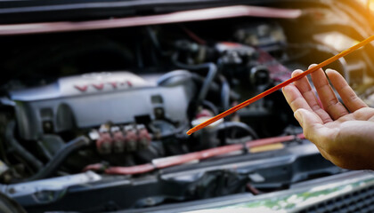 Hands man auto mechanic checking lube oil level of car engine on car engine background for...