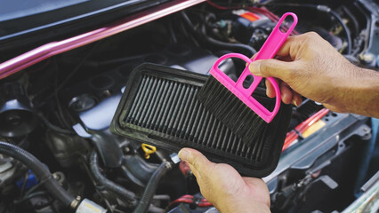 Hands man auto mechanic holding brush to clean dirty car air filters, cleaning process on car...