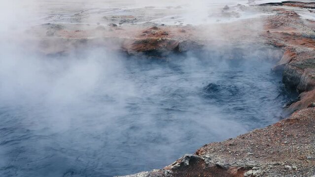 Bubbling gray mud puddles in Hverir, Iceland. Geothermal area, strong sulfur smell. Toxic gases and unstable ground. Heat causes the water to evaporate and mix with mud.