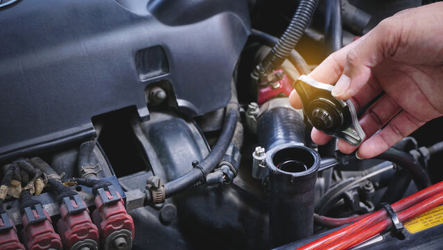 Hands man auto mechanic checking coolant  water level in radiator car engine on car engine background for maintenance or repair service concept.