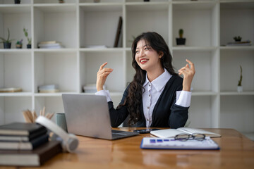 Freelance Asian woman enjoying video call on her laptop Remote work and communications.