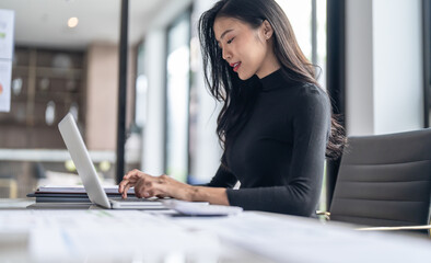 Beautiful confident asian business woman working with laptop Hands typing  keyboard. Professional investor working new start up project. business planning in office. Technology business