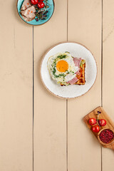 A detailed view of a mouth-watering Viennese waffle, adorned with succulent bacon and a glistening egg. The beige wooden backdrop and fresh ingredients accentuate its visual appeal