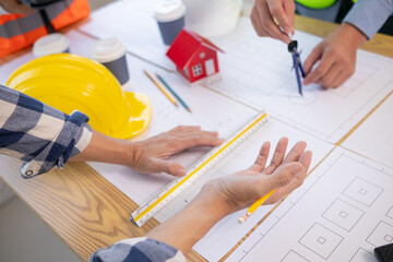 Architects and construction engineers meet to discuss blueprints of building structures in order to calculate the completion of the construction project. Real estate construction business concept.