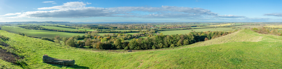 Wide panorama from Burton Dassett Hills on a bright autumnal day with far reaching views over Warwickshire, England - 673895283