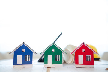 model house rests on desks of engineers and designers to please investors with the design work before they begin. concept about designing a house or real estate to meet the needs of investors.