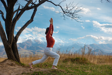 Young woman is practicing yoga in lotus pose at mountain