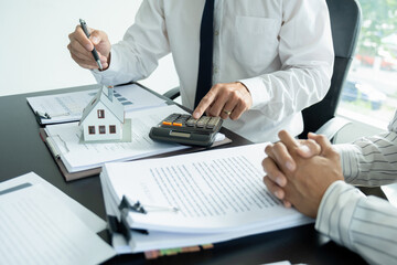 Businesswoman embraces client after successful property negotiation.