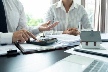 Businesswoman embraces client after successful property negotiation.