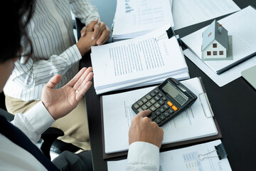 Businesswoman embraces client after successful property negotiation.