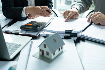 Businesswoman embraces client after successful property negotiation.