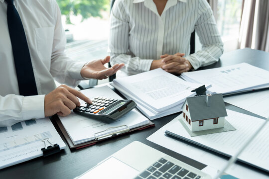 Businesswoman embraces client after successful property negotiation.