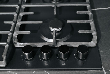 Modern gas stove, burner and round adjustment knobs close-up