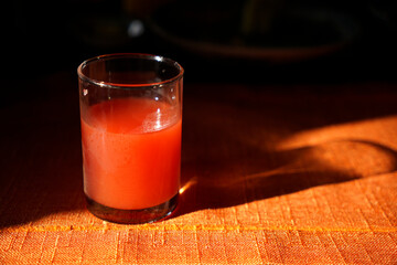 Watermelon juice in a glass on table with morning sunlight and shade