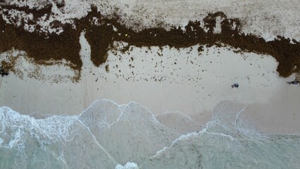 Aerial view of Ocean waves crashing onto a sandy shoreline