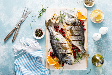 Dorado fish grilled with oranges, cranberries and rosemary, Mediterranean food. Christmas festive...