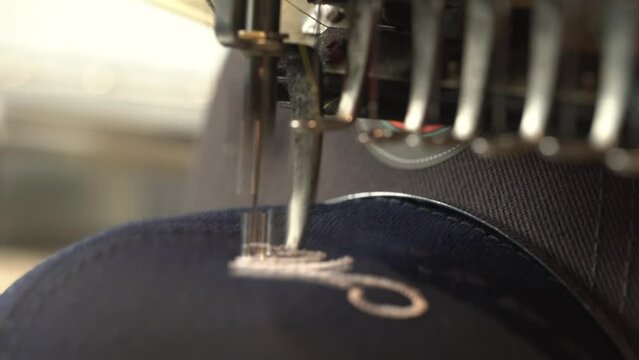 Automatic sewing machine needle in work process. Close-up of sewing machine needle in motion rapidly moves up and down.