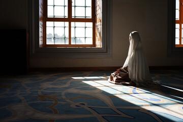 Arabic muslim woman praying in mosque. 
