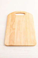 Empty rectangular wooden cutting board on white wooden. Side view