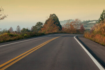 View on the road in the countryside during autumn season at sunrise.