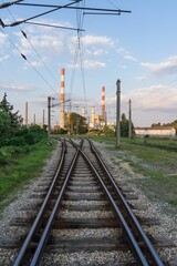 Fototapeta na wymiar Scenic view of an industrial complex featuring multiple train tracks and power lines
