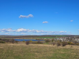 A grassy field with a body of water in the distance